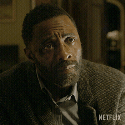 A Man With A Beard Is Sitting With His Hands Folded In Front Of A Netflix Sign GIF