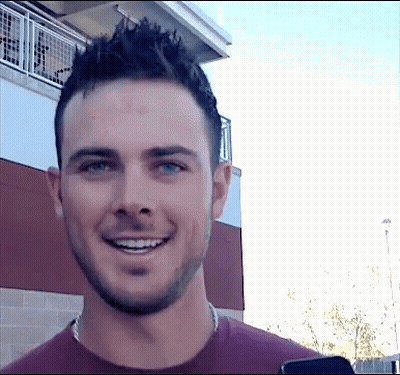 A Man With A Beard Is Smiling And Looking At The Camera GIF