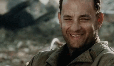 A Man With A Beard Is Smiling And Looking At The Camera In A Movie . GIF