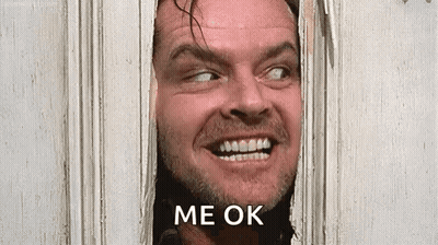 A Man With A Beard Is Smiling And Looking Through A Door . GIF