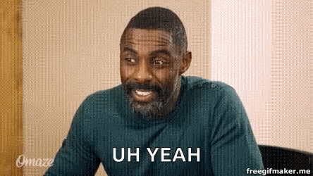 A Man With A Beard Is Smiling And Saying `` Uh Yeah '' While Sitting At A Table . GIF