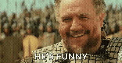 A Man With A Beard Is Smiling And Says `` He 'S Funny '' . GIF