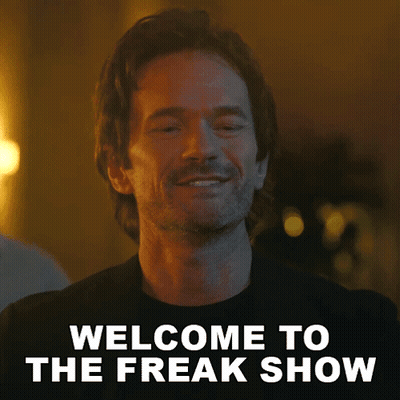 A Man With A Beard Is Smiling And Says Welcome To The Freak Show . GIF