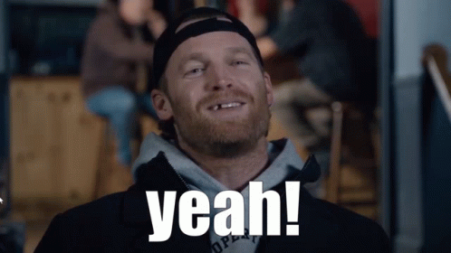 A Man With A Beard Is Smiling And The Word Yeah Is On His Shirt GIF
