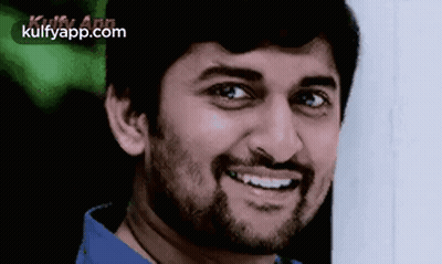 A Man With A Beard Is Smiling And Wearing A Blue Shirt GIF