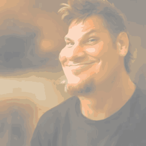 A Man With A Beard Is Smiling And Wearing A Green And Purple Shirt GIF