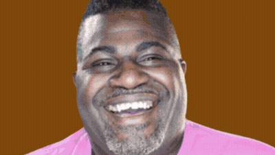 A Man With A Beard Is Smiling In Front Of A Colorful Sign That Says Bubbly GIF