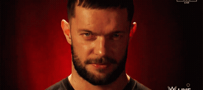 A Man With A Beard Is Smiling In Front Of A Red Background That Says Wwe Live GIF