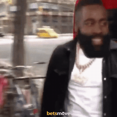 A Man With A Beard Is Smiling In Front Of A Sign That Says Betsmove On It GIF