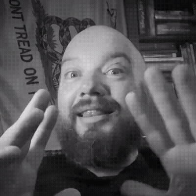 A Man With A Beard Is Smiling In Front Of A Sign That Says " Dont Tread On " GIF