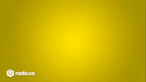 A Man With A Beard Is Smiling In Front Of A Yellow Background With Radio.co Written On The Bottom GIF