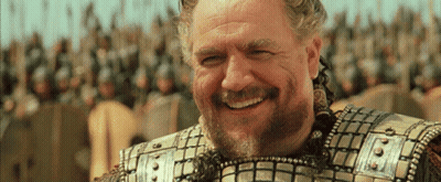 A Man With A Beard Is Smiling In Front Of Soldiers GIF