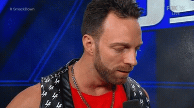 A Man With A Beard Is Smiling While Talking Into A Microphone . GIF