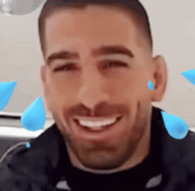 A Man With A Beard Is Smiling With Blue Drops Of Water On His Face . GIF