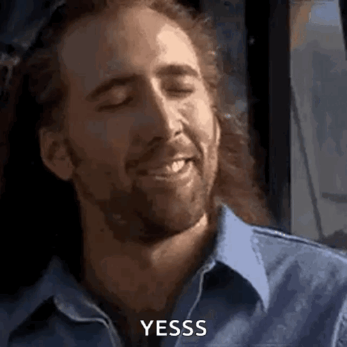 A Man With A Beard Is Smiling With His Eyes Closed . GIF