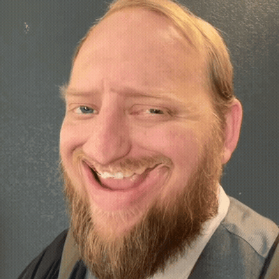 A Man With A Beard Is Smiling With His Tongue Sticking Out GIF
