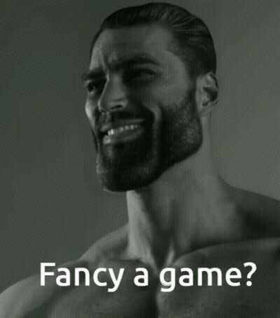 A Man With A Beard Is Smiling With The Words Fancy A Game Behind Him GIF