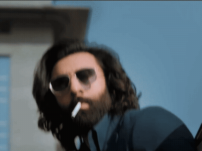 A Man With A Beard Is Smoking A Cigarette GIF