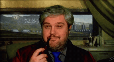 A Man With A Beard Is Smoking A Pipe In Front Of A Picture Of Mountains GIF