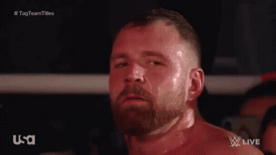A Man With A Beard Is Standing In A Boxing Ring Looking At The Camera . GIF