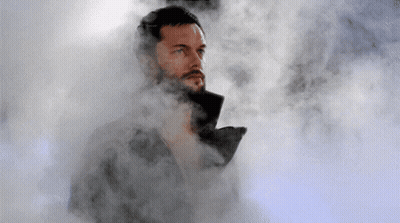 A Man With A Beard Is Standing In A Cloud Of Smoke GIF