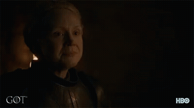 A Man With A Beard Is Standing In A Dark Room With The Word Got Written On The Bottom GIF