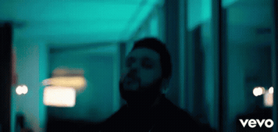 A Man With A Beard Is Standing In A Dark Room With The Word Vevo On The Bottom GIF