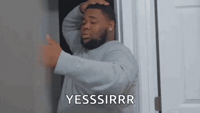 A Man With A Beard Is Standing In A Doorway Holding His Head And Giving A Thumbs Up . GIF
