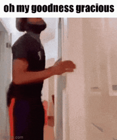 A Man With A Beard Is Standing In A Hallway With The Words Oh My Goodness Gracious Above Him . GIF