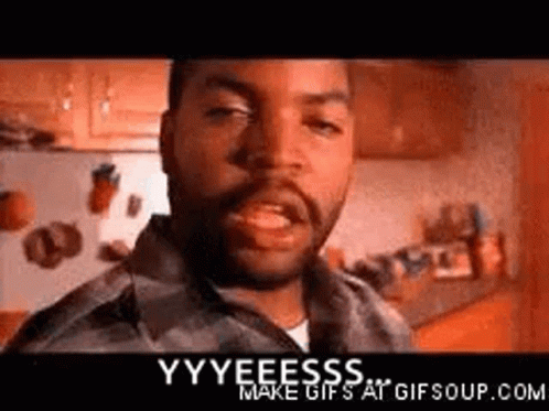 A Man With A Beard Is Standing In A Kitchen And Making A Funny Face . GIF