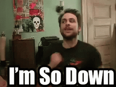 A Man With A Beard Is Standing In A Room With The Words `` I 'M So Down '' Written On The Screen . GIF