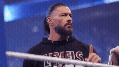 A Man With A Beard Is Standing In A Wrestling Ring And Giving The Middle Finger . GIF