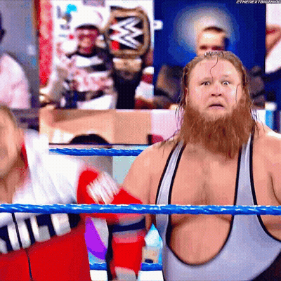 A Man With A Beard Is Standing In A Wrestling Ring With A W Logo In The Background GIF