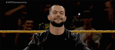 A Man With A Beard Is Standing In A Wrestling Ring With His Arms Outstretched . GIF