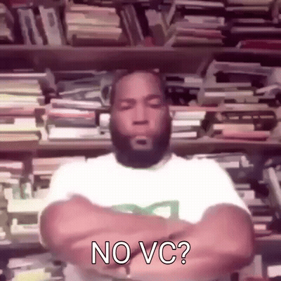 A Man With A Beard Is Standing In Front Of A Bookshelf With His Arms Crossed And Says No Vc . GIF