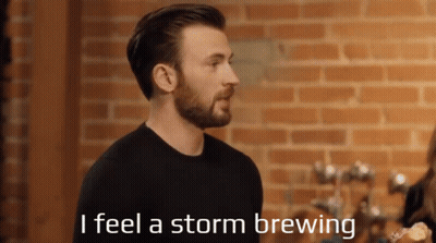 A Man With A Beard Is Standing In Front Of A Brick Wall And Says " I Feel A Storm Brewing " GIF