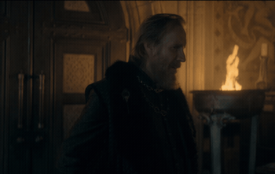 A Man With A Beard Is Standing In Front Of A Candle GIF