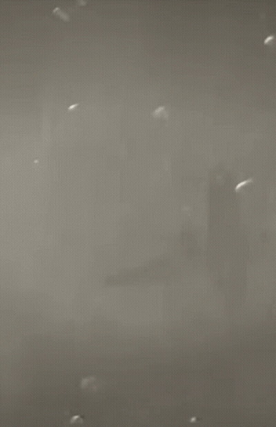 A Man With A Beard Is Standing In Front Of A City In A Black And White Photo GIF