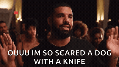 A Man With A Beard Is Standing In Front Of A Crowd Holding His Hands Up . GIF