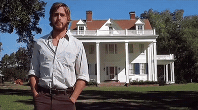 A Man With A Beard Is Standing In Front Of A Large White House . GIF
