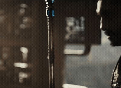 A Man With A Beard Is Standing In Front Of A Microphone . GIF
