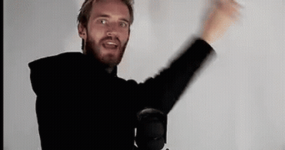 A Man With A Beard Is Standing In Front Of A Microphone With His Arms In The Air . GIF