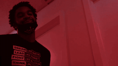 A Man With A Beard Is Standing In Front Of A Red Door GIF