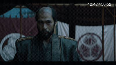 A Man With A Beard Is Standing In Front Of A Screen That Says 12:42 / 56.52 GIF