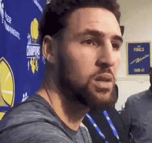A Man With A Beard Is Standing In Front Of A Sign That Says Champions GIF