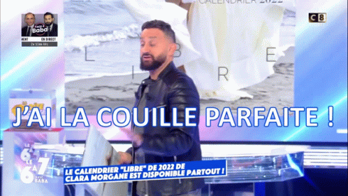 A Man With A Beard Is Standing In Front Of A Sign That Says J'ai La Coulle Parfaite GIF