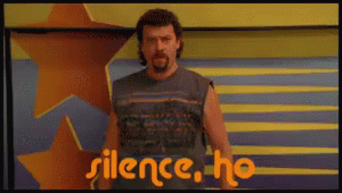A Man With A Beard Is Standing In Front Of A Sign That Says Silence Ho GIF