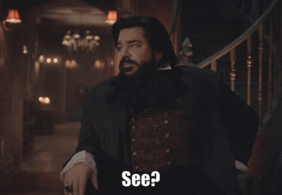 A Man With A Beard Is Standing In Front Of A Staircase And Says " See " GIF