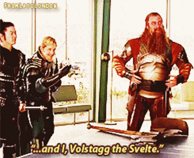 A Man With A Beard Is Standing In Front Of A Table With The Words " And I Volstagg The Svelte " GIF