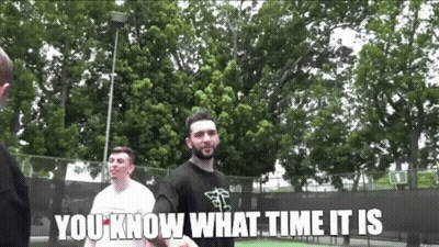 A Man With A Beard Is Standing In Front Of A Tennis Court With The Words " You Know What Time It Is " Below Him GIF